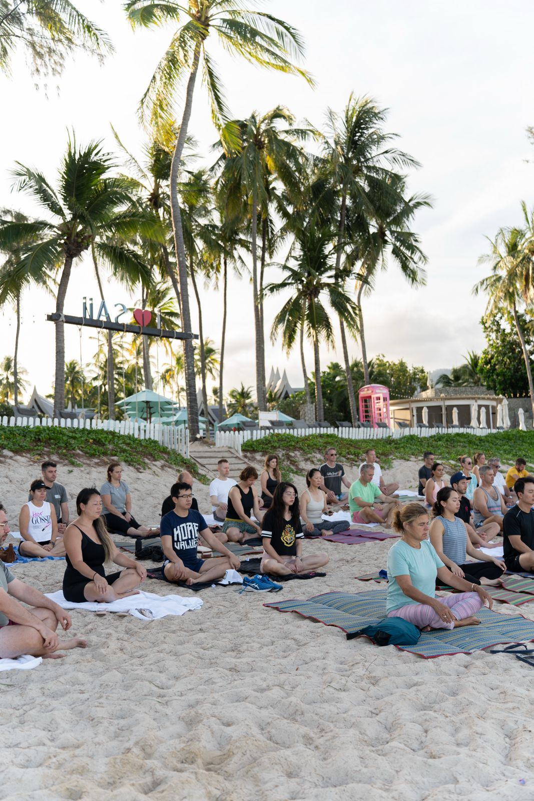 Retreat members in a morning yoga session on the beach in Phuket